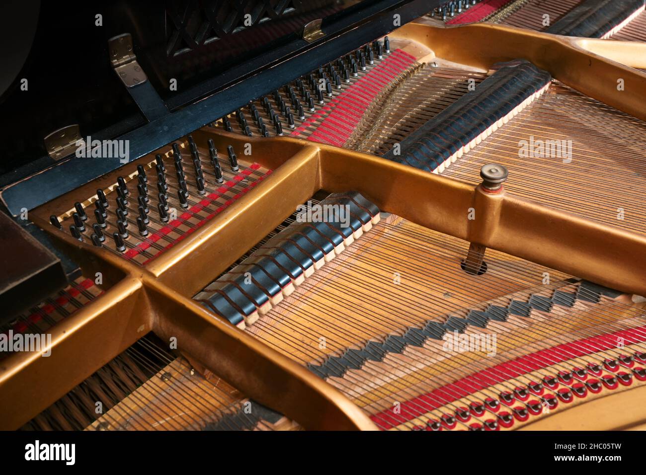 Inside a grand piano, metal frame, strings and mechanics of the old acoustic musical instrument, music themes, selected focus narrow depth of field Stock Photo