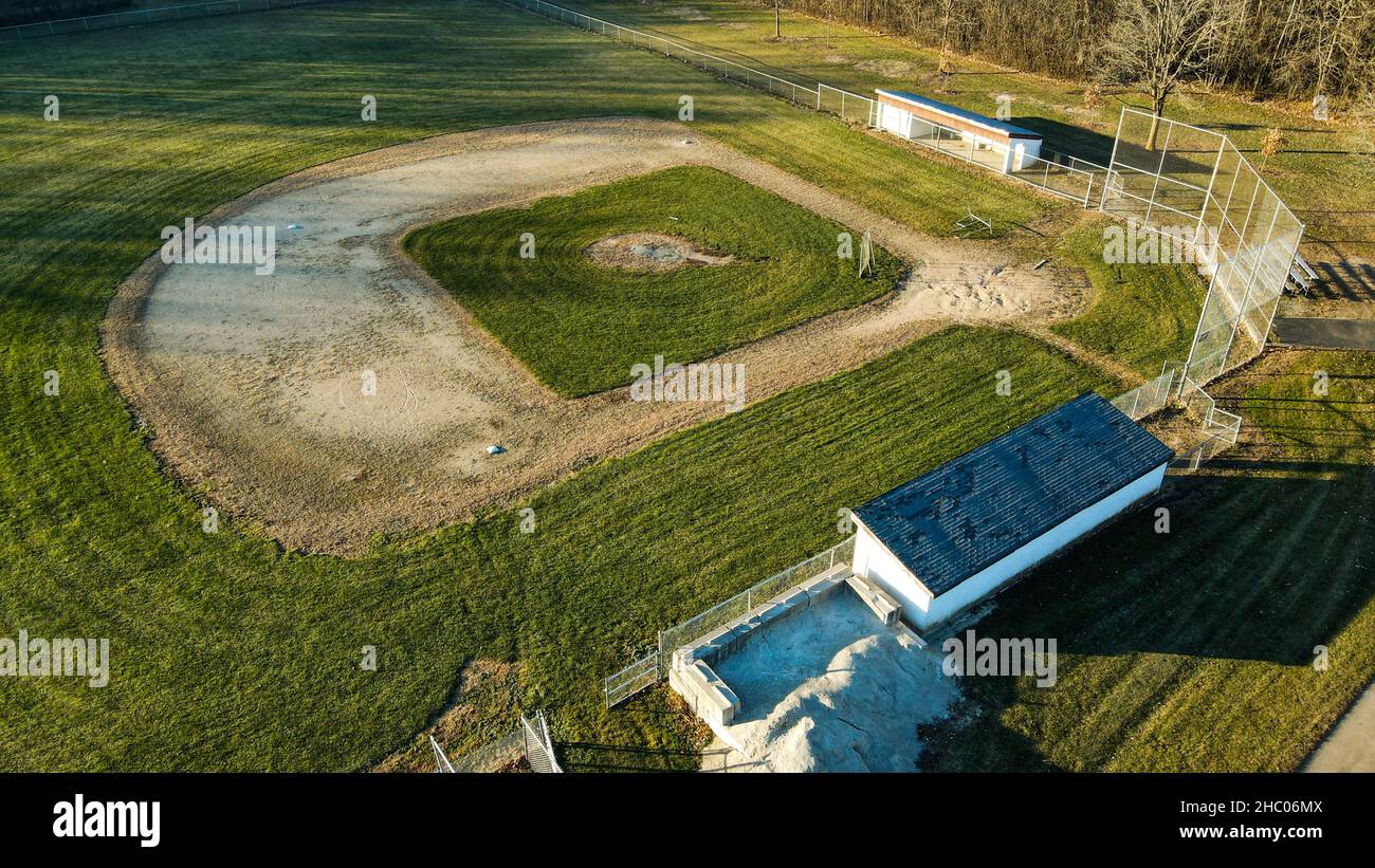 Early morning sun lights up the empty park baseball field Stock Photo