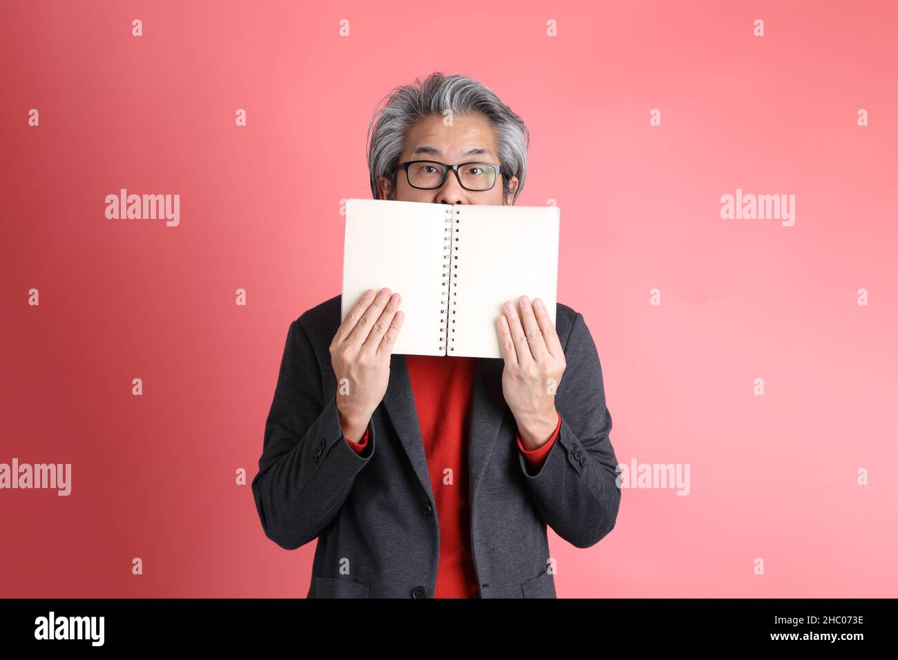 The Asian man standing on the pink background. Stock Photo