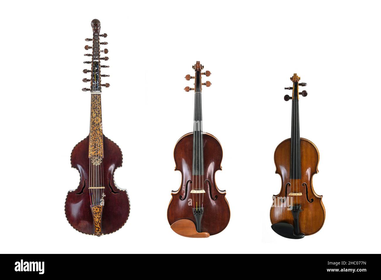 Three stringed musical instruments of the viol family in comparison, viola d amore, viola and violin, isolated on a white background, copy space Stock Photo