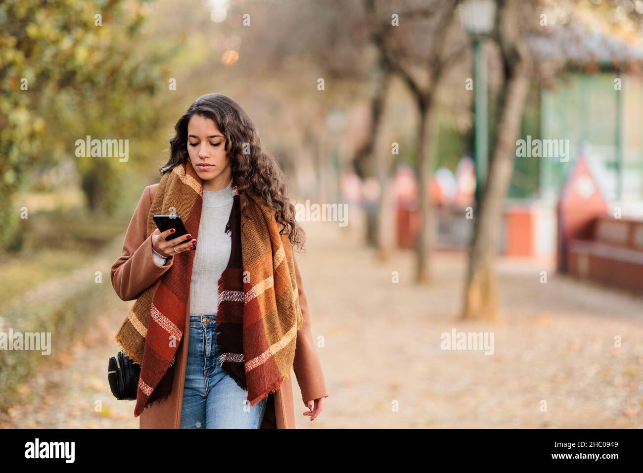 Spanish business woman communicating with smartphone in Castilla la mancha, Toledo. Fall colors Stock Photo