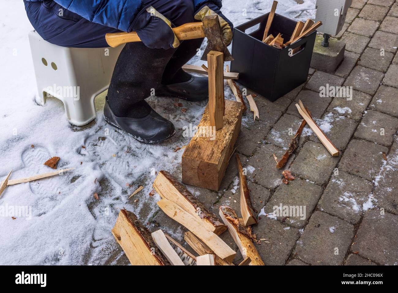 Close up view of man chopping wood chips kindling of fireplace. Sweden. Stock Photo