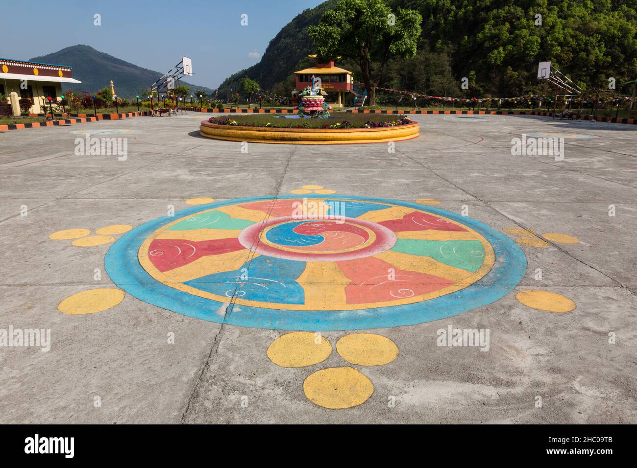 A dharma wheel painted on the cement of the schoolyard at the Pema Tsal Sakya Monastery near Pokhara, Nepal. Stock Photo