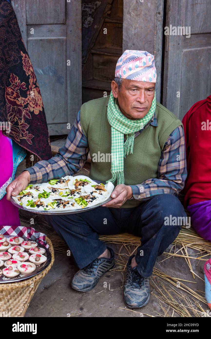 A Nepali man in a Dhaka topi cap with food for the Navadurga Festival, a Hindu celebration in Bhaktapur, Nepal. Stock Photo