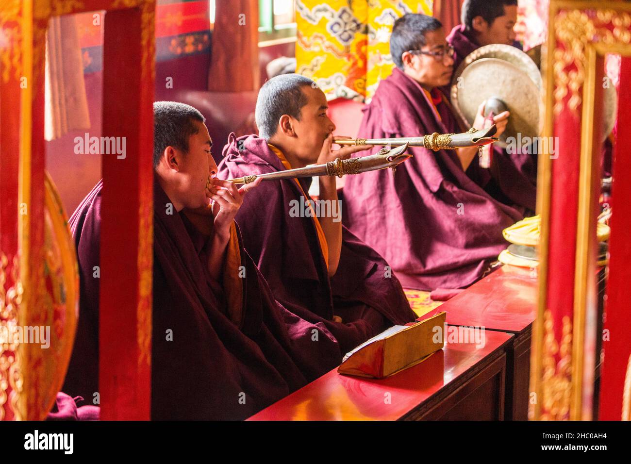 Young novice Buddhist monks play Tibetan trumpets in a monastery at the Swayambhunath complex in Kathmandu, Nepal. Stock Photo