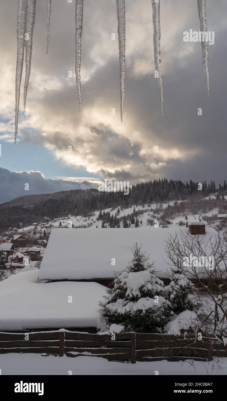 Window view of Carpathian mountains with icicles from above Stock Photo