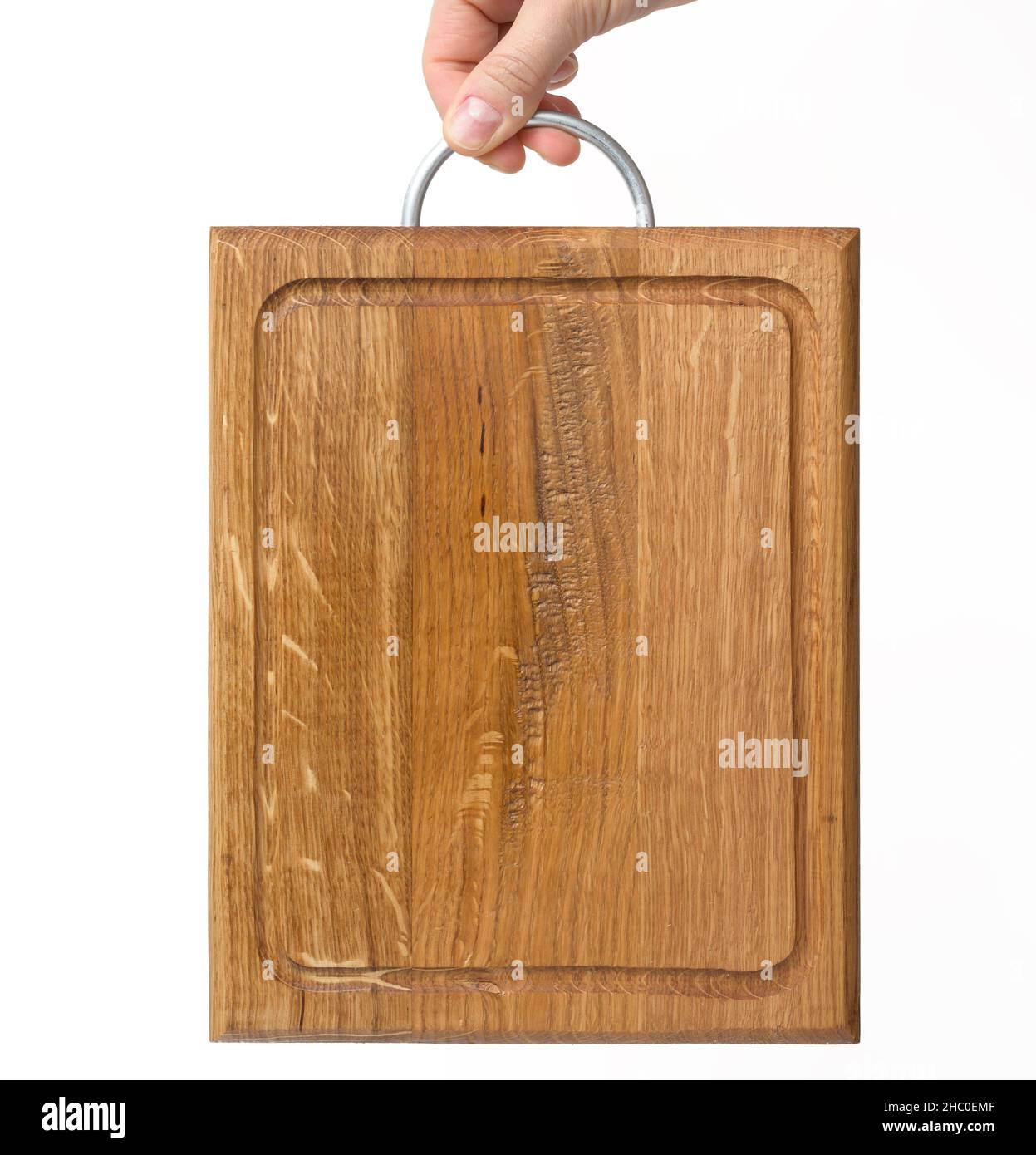 female hands hold empty rectangular brown wooden chopping board on white background Stock Photo