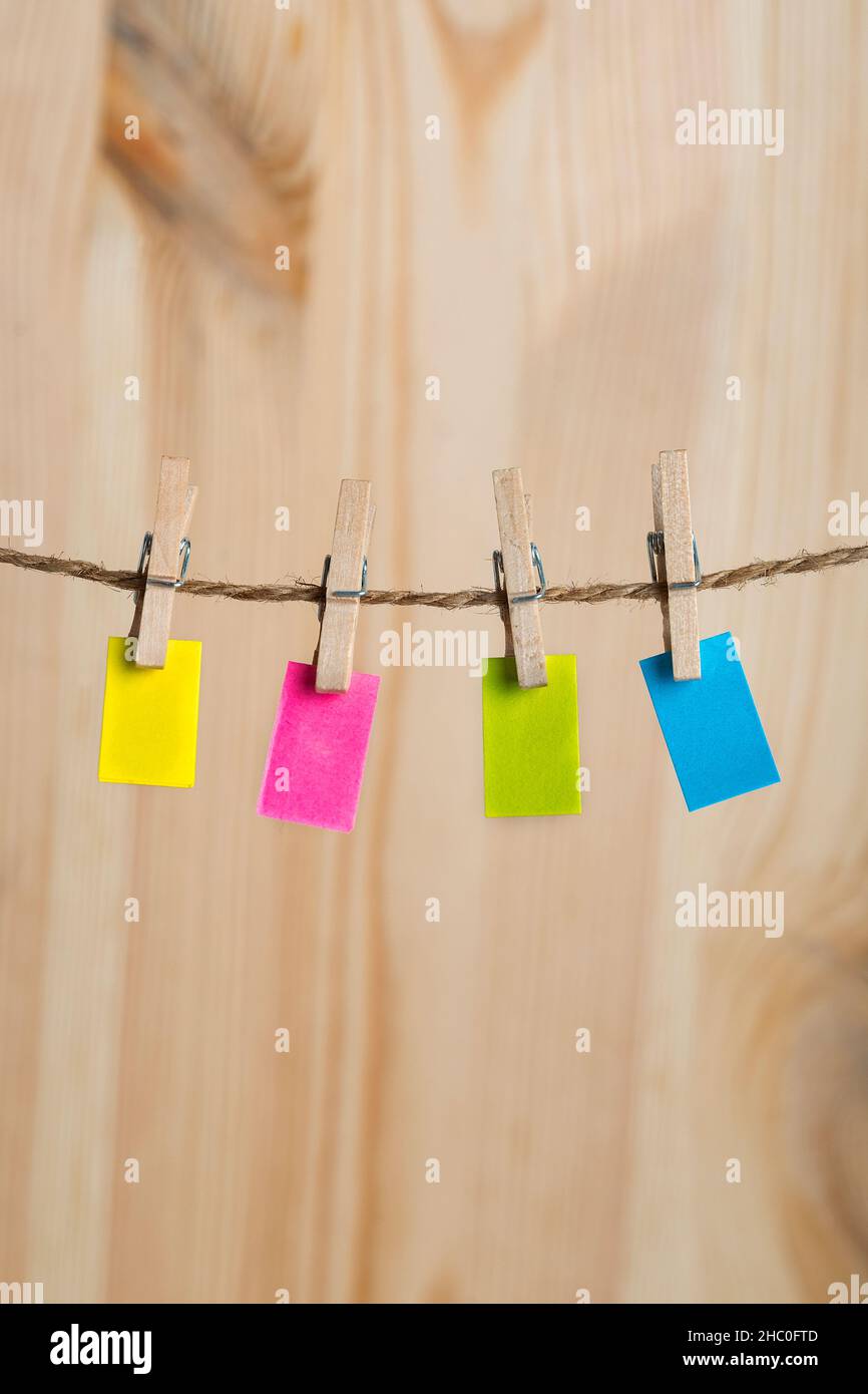 Multicolored paper notes hang with clothespins on rope. Copy space ...