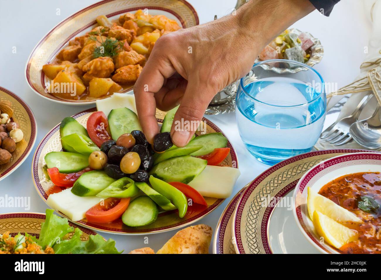 Hand take black olive on Ramadan-Iftar Table,close-up Stock Photo
