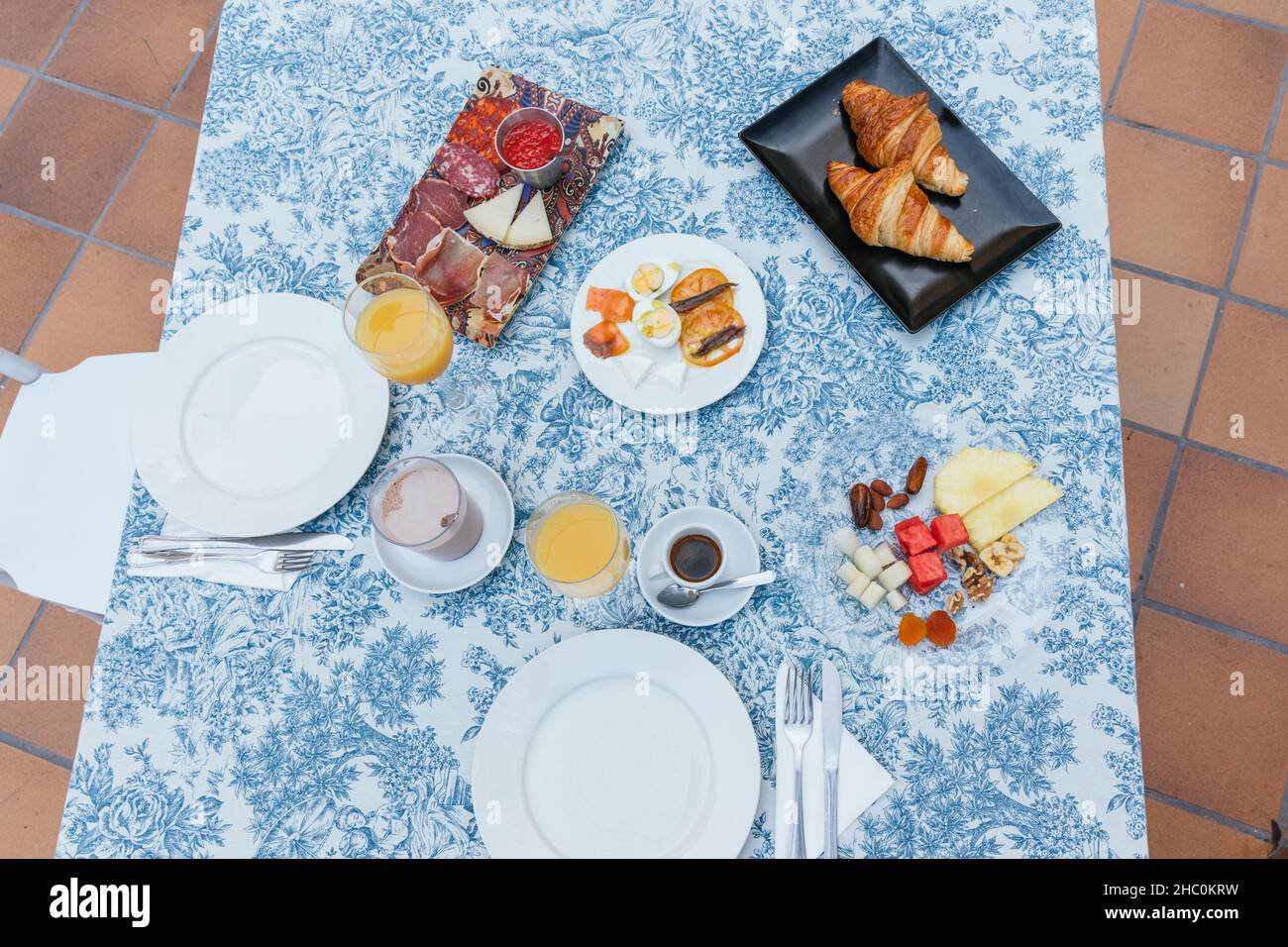 Continental breakfast on a terrace with orange juice, fruit, cocoa