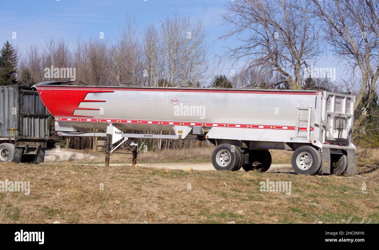MAC Trailer MAC SIMIZER round bottom dump trailer parked at a rural semi trailer and truck maintenance facility. Stock Photo