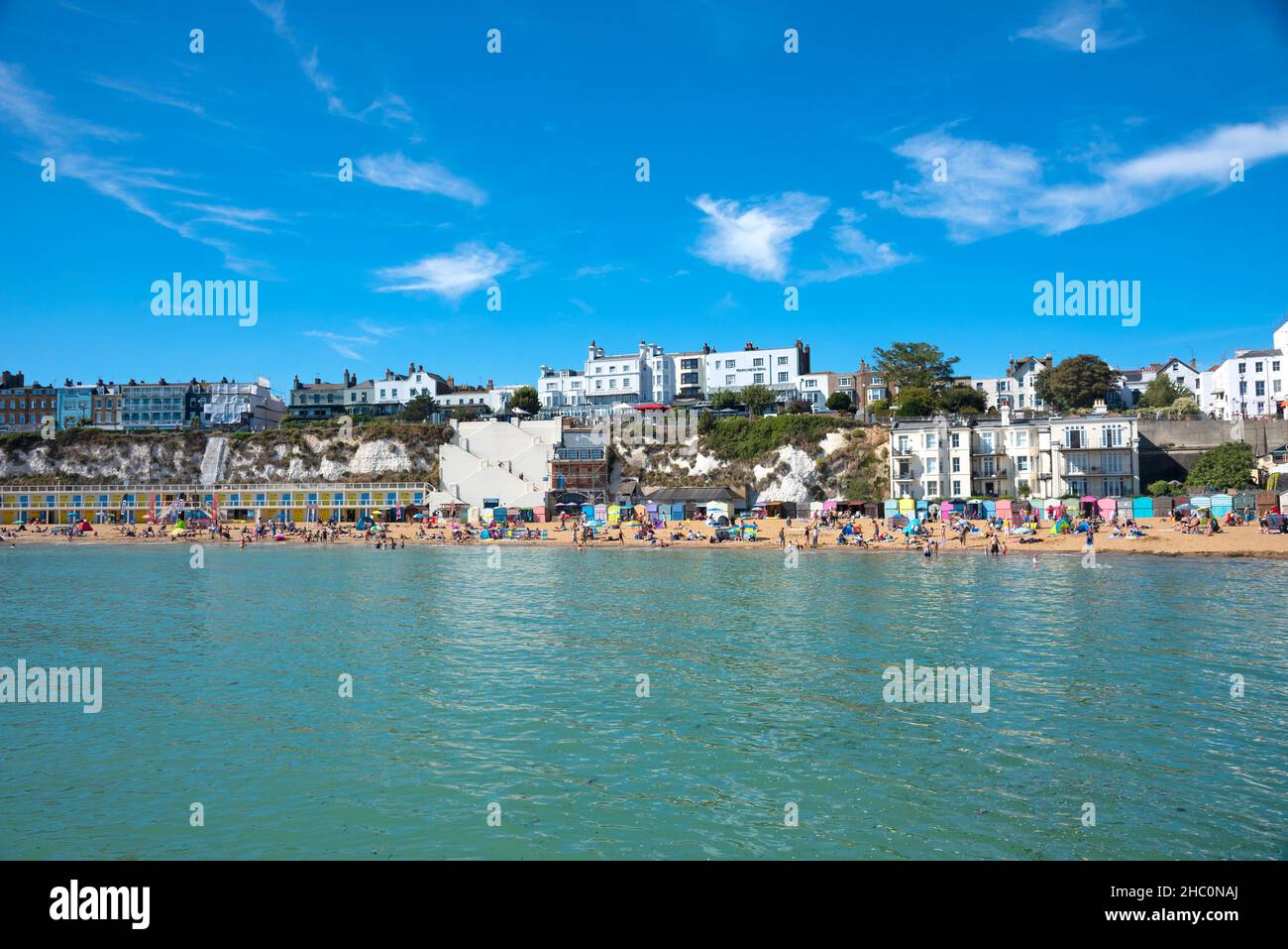 People sunbathing and playing on beach in Broadstairs in Kent Stock Photo