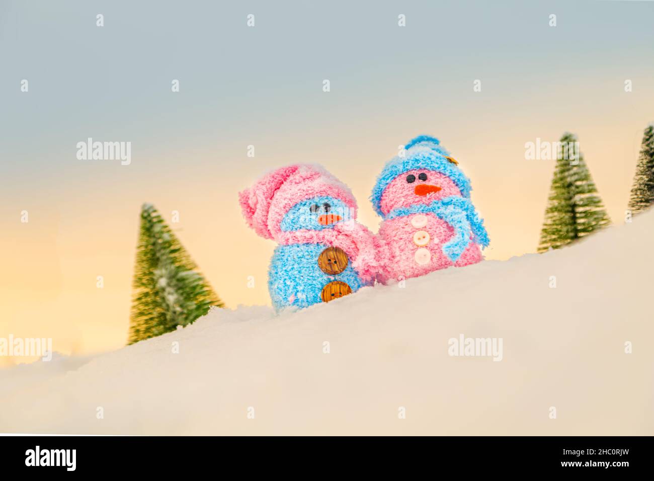 Cute homemade snowmen with scarves and hats on the mountain. Winter's Tale. Greeting card with copy space. Winter background. Stock Photo