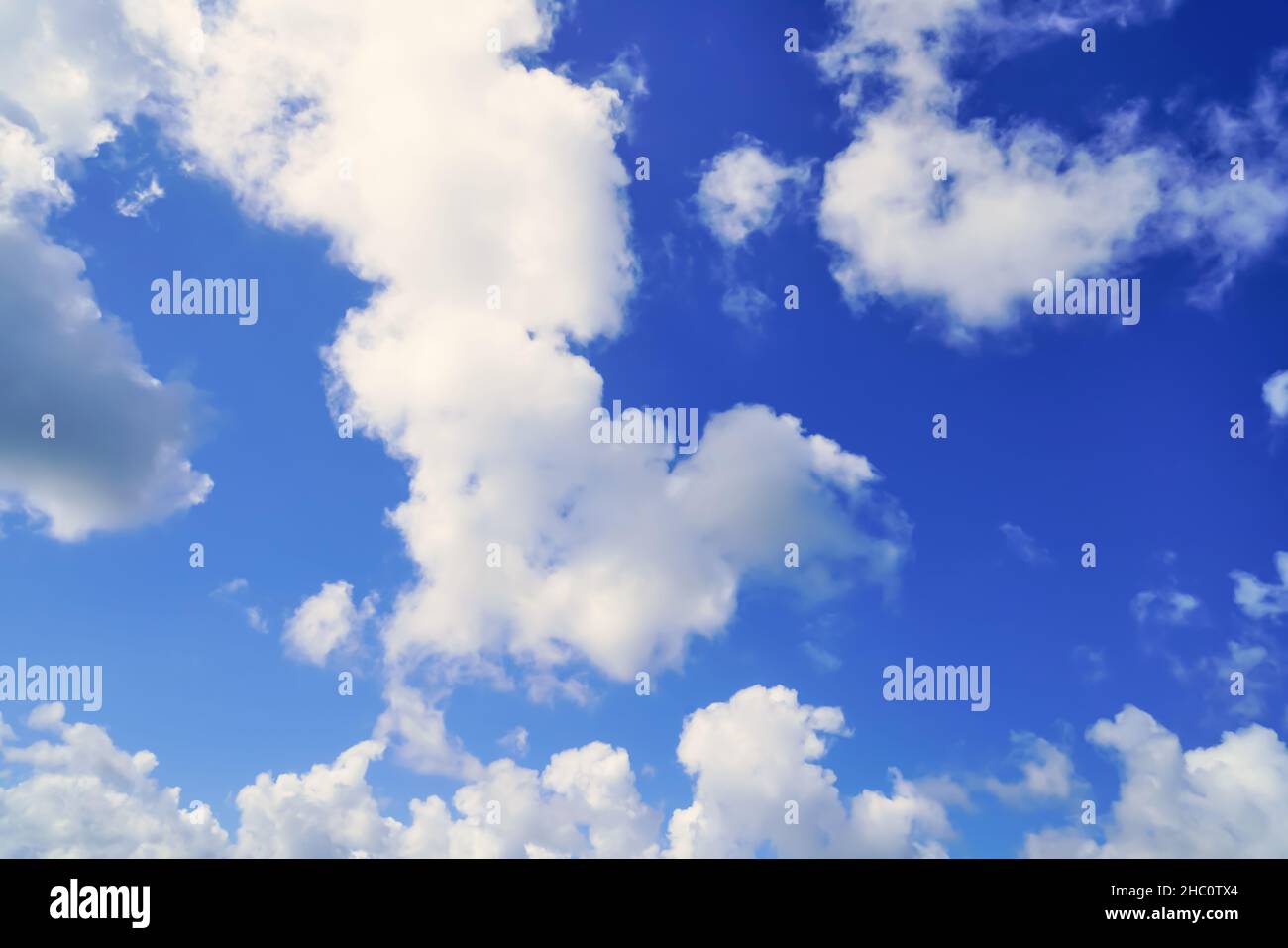 Fluffy white clouds on a bright blue sky. Nature background Stock Photo ...