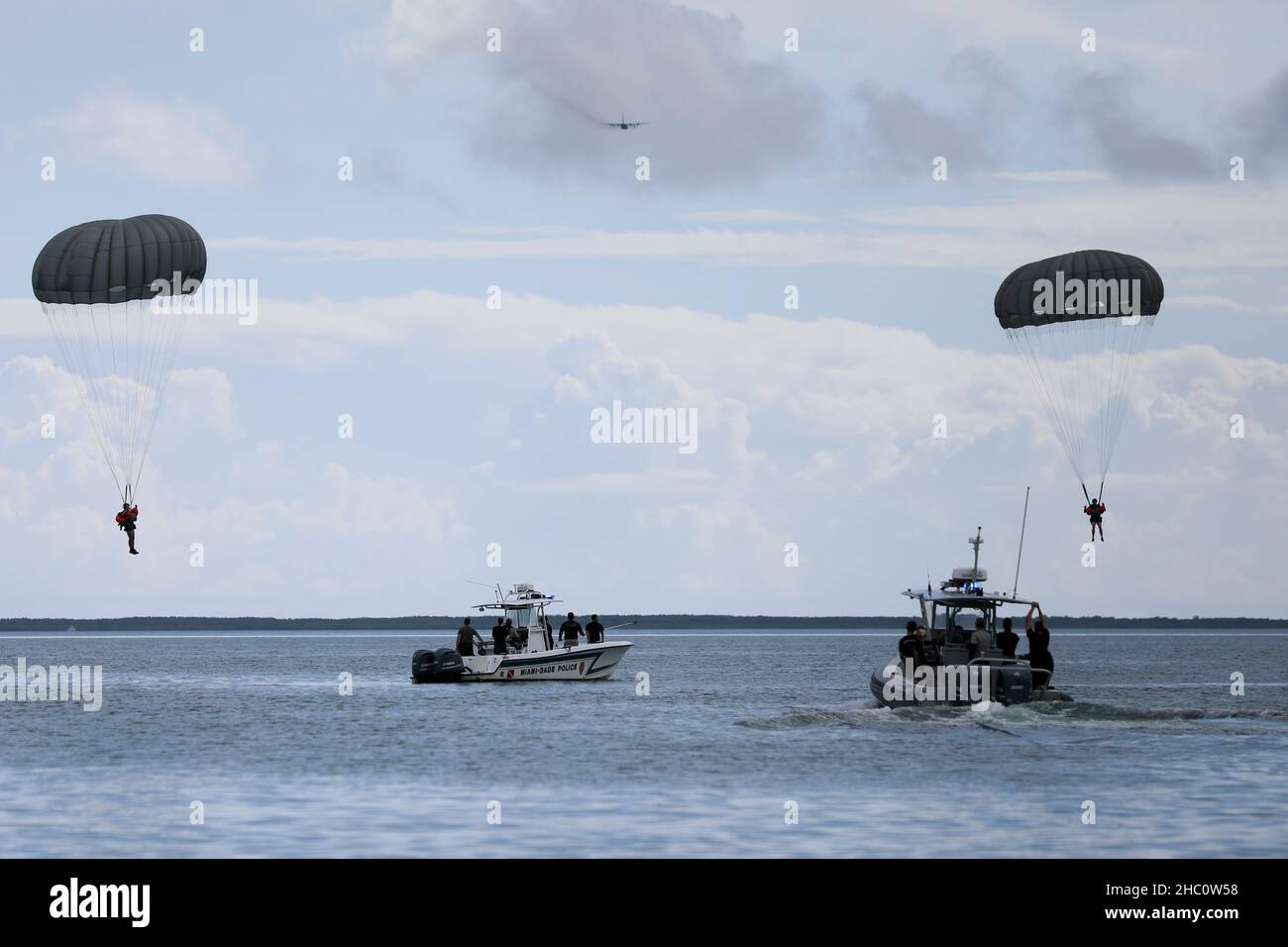 Rescue boats head toward U.S. Army Reserve paratroopers in Biscayne Bay, Miami-Dade County, as they complete their Deliberate Water Jump. The U.S. Army Civil Affairs and Psychological Operations Command (Airborne) Paratroopers were participating in the jump as a conclusion to the Army Reserve Airborne Safety Equipment and Evaluation Council held Nov 16-19, 2021, in Homestead, Florida.     The weeklong event, hosted by the 478th Civil Affairs Battalion (Airborne), Perrine, Florida, 1st Civil Affairs and Psychological Operations Training Brigade, included a Jumpmaster Refresher course, the AR-AS Stock Photo