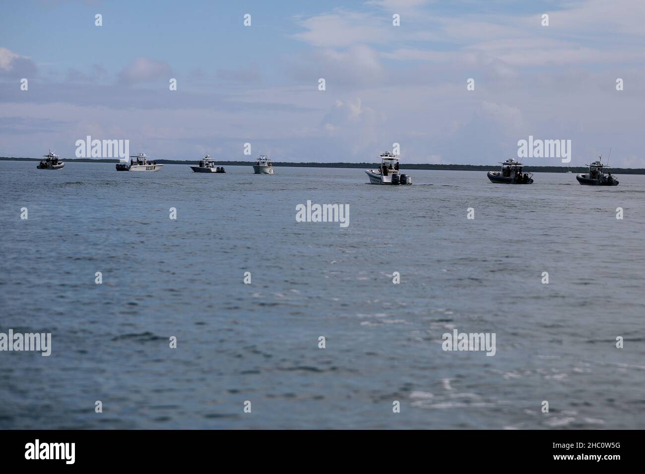 Recovery boats await the next round of U.S. Army Reserve paratroopers during a Deliberate Water Jump, Biscayne Bay, Miami-Dade County, Florida, Nov. 19, 2021. The jump was part of the U.S. Army Civil Affairs and Psychological Operations Command (Airborne) week-long Army Reserve Airborne Safety Equipment and Evaluation Council in Homestead, Florida.    Hosted by the 478th Civil Affairs Battalion (Airborne), Perrine, Florida, 1st Civil Affairs and Psychological Operations Training Brigade, the jump involved coordination with several outside agencies including the Coast Guard, and Miami-Dade Poli Stock Photo