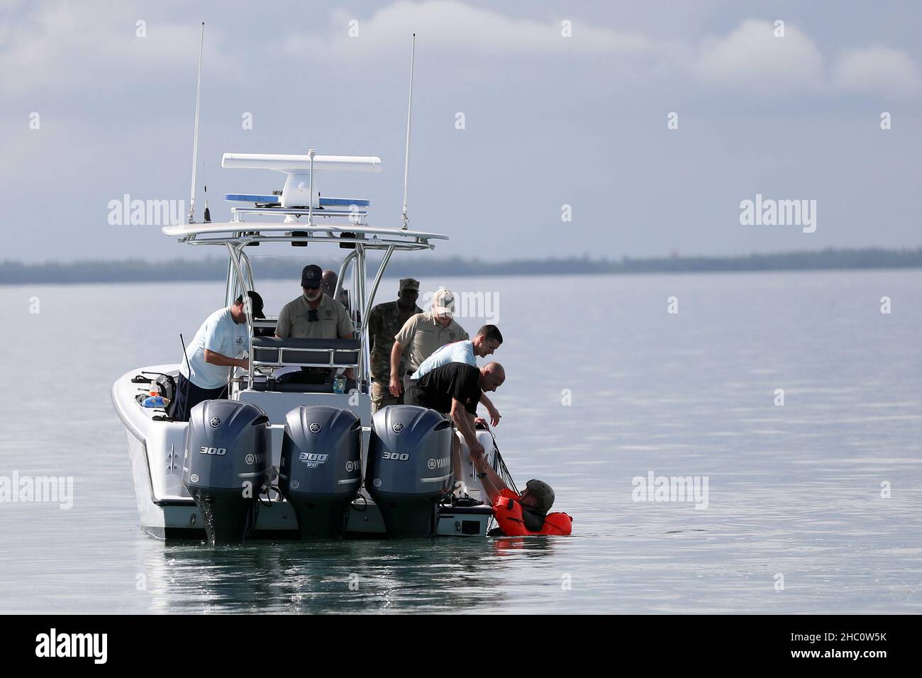 A U.S. Army Reserve paratrooper is assisted into a rescue boat following his Deliberate Water Jump into Biscayne Bay, Miami-Dade County on Nov. 19, 2021. The airborne operation was the culminating event of a weeklong training hosted by the 478th Civil Affairs Battalion (Airborne), Perrine, Florida, 1st Civil Affairs and Psychological Operations Training Brigade, U.S. Army Civil Affairs and Psychological Operations Command (Airborne).     The USACAPOC(A) weeklong training included a Jumpmaster Refresher course, the Army Reserve Airborne Safety Equipment and Evaluation Council, airborne operatio Stock Photo