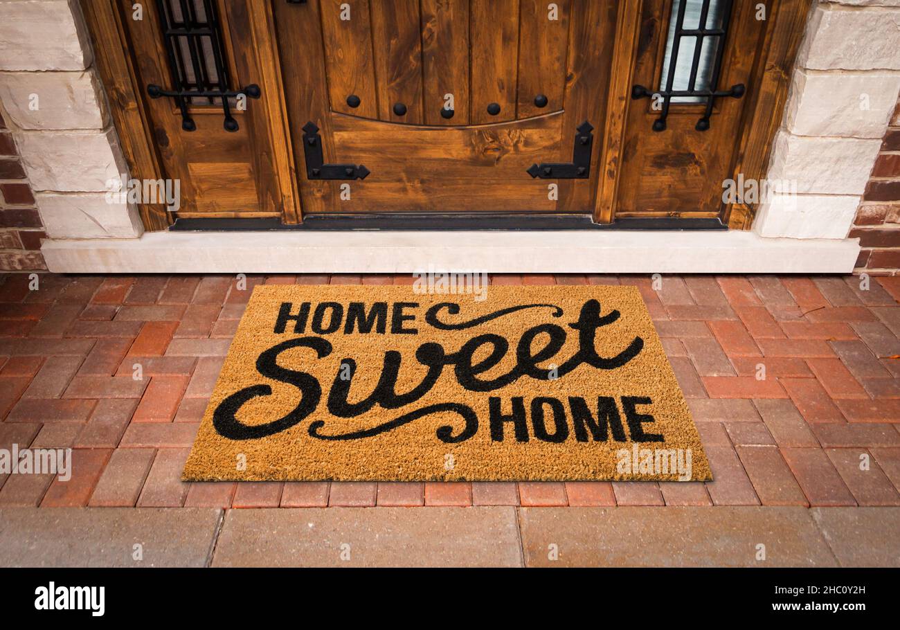 Home Sweet Home Welcome Mat At Custom Front Door of House. Stock Photo