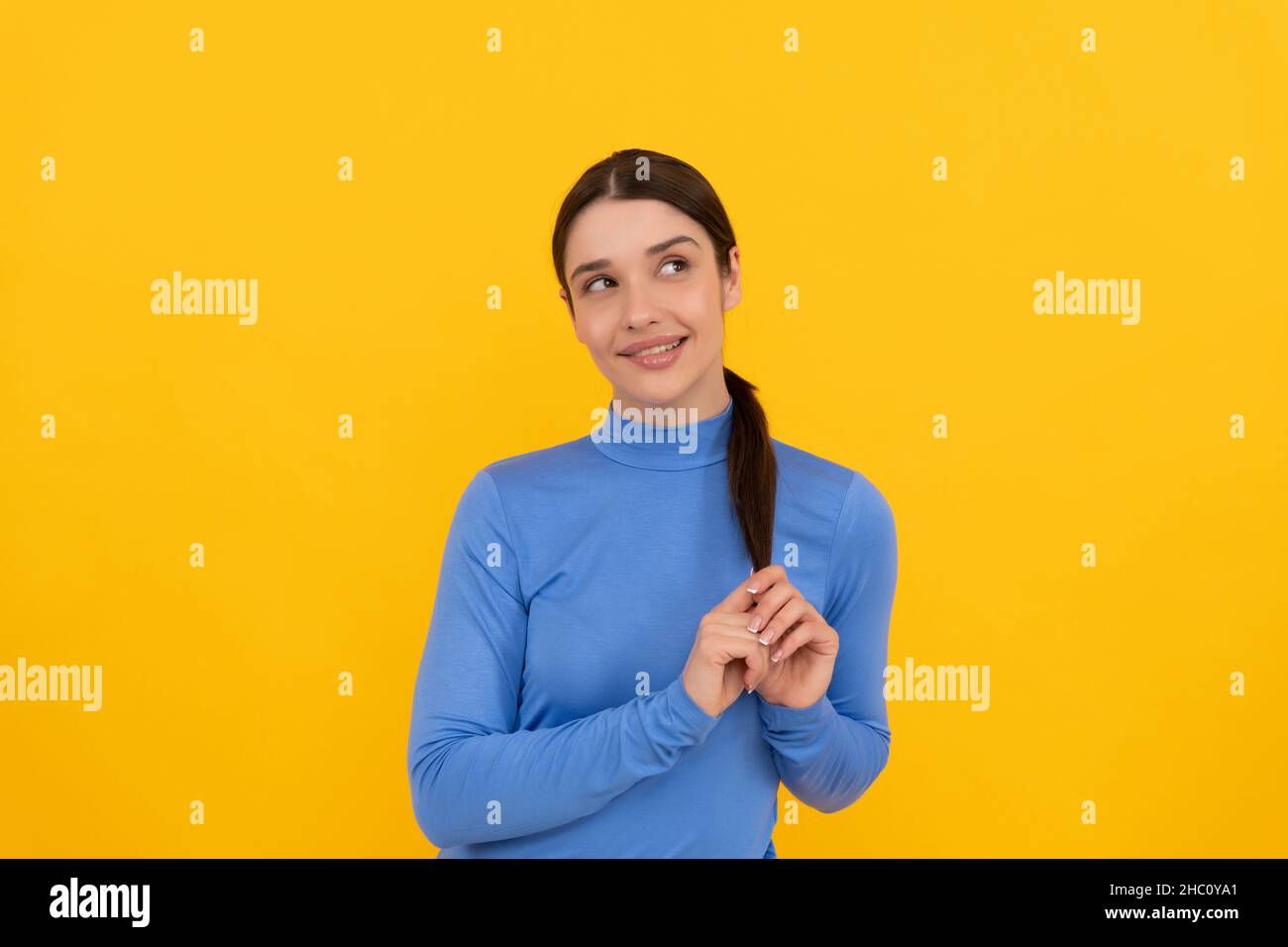 smiling woman portrait touch hair on yellow background, emotions Stock Photo Alamy