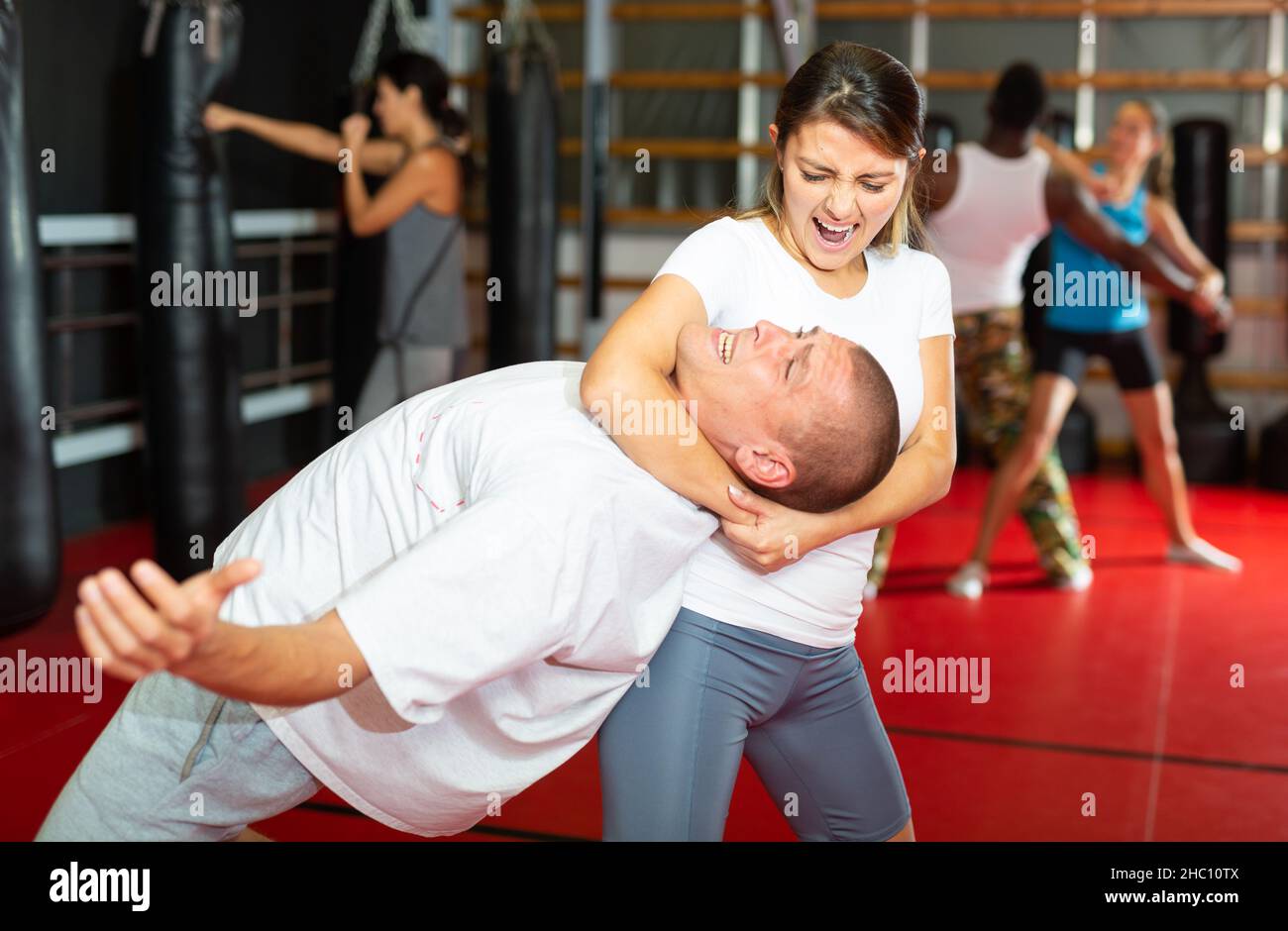 Woman practising neck grabbing move in gym Stock Photo Alamy