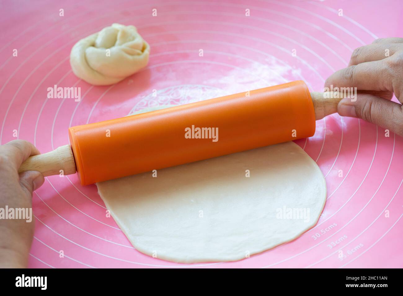 Closed up photo of woman hands use dough rollers to make roti or