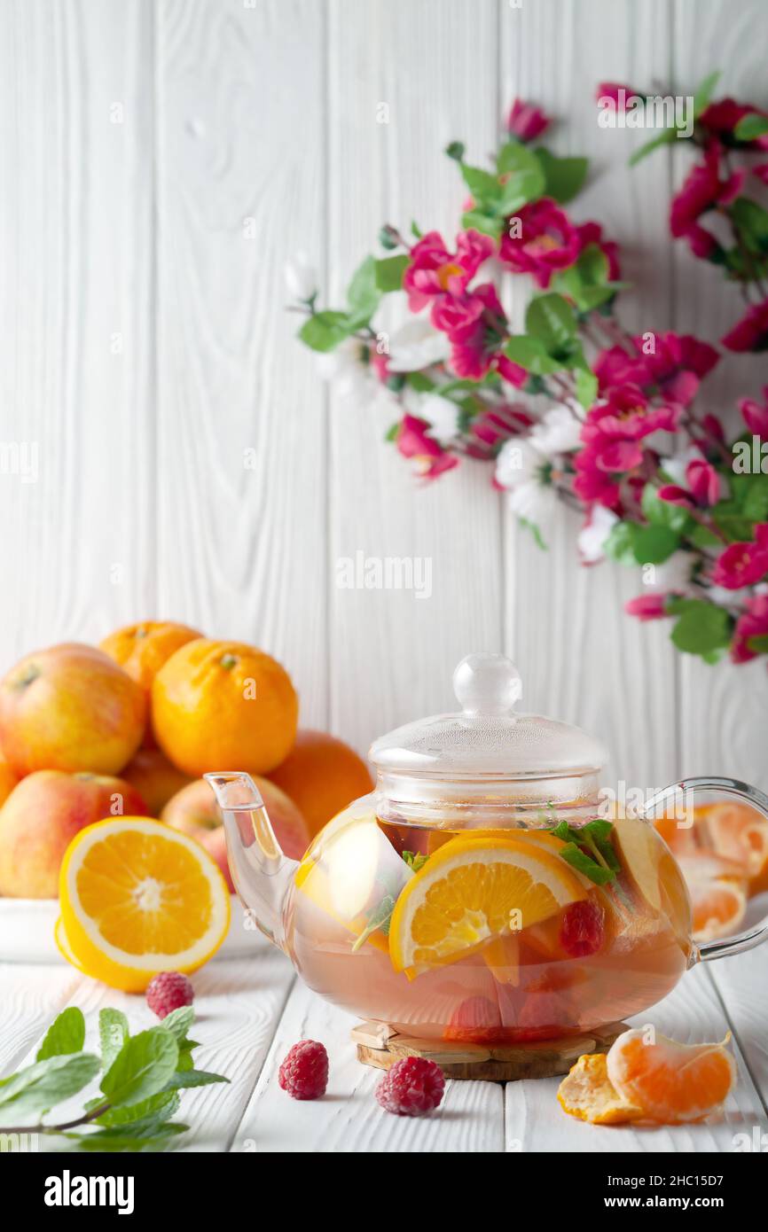 Fruit tea with berries, oranges and mint in a glass teapot on a white background Stock Photo