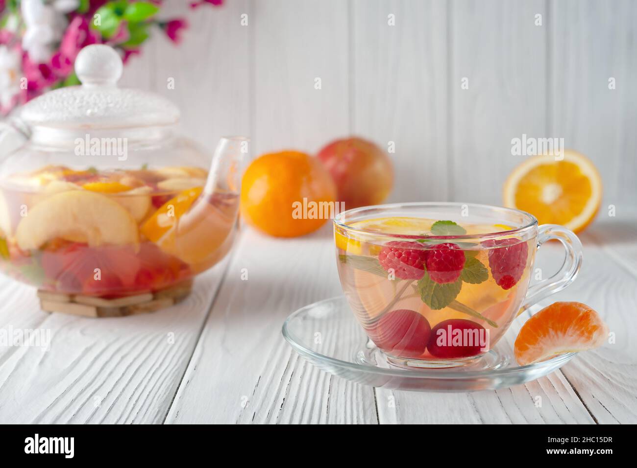 Fruit tea with berries, oranges and mint in a glass teapot on a white background Stock Photo