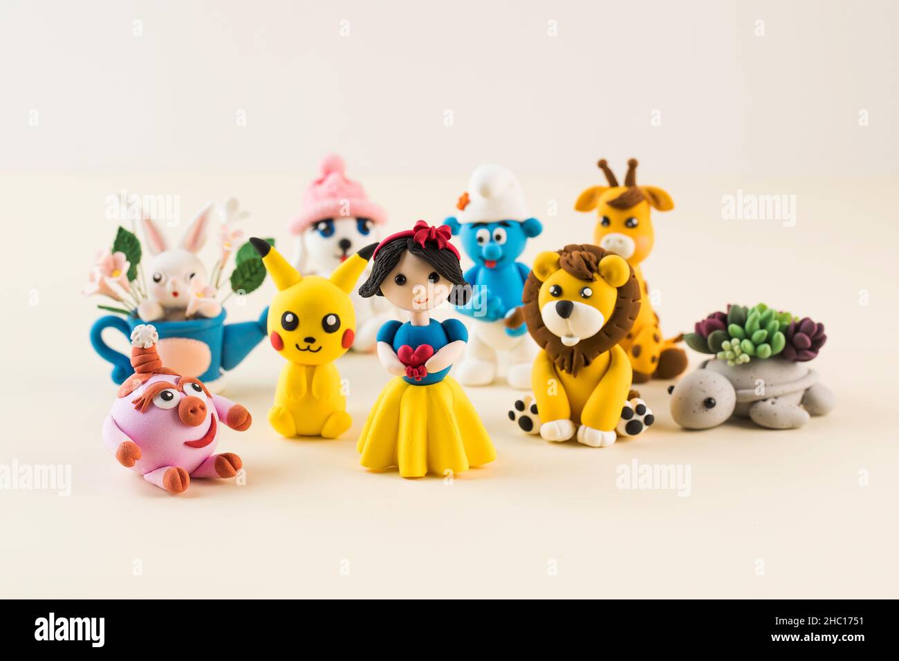 Toy figures of cartoon characters made of polymer clay on light