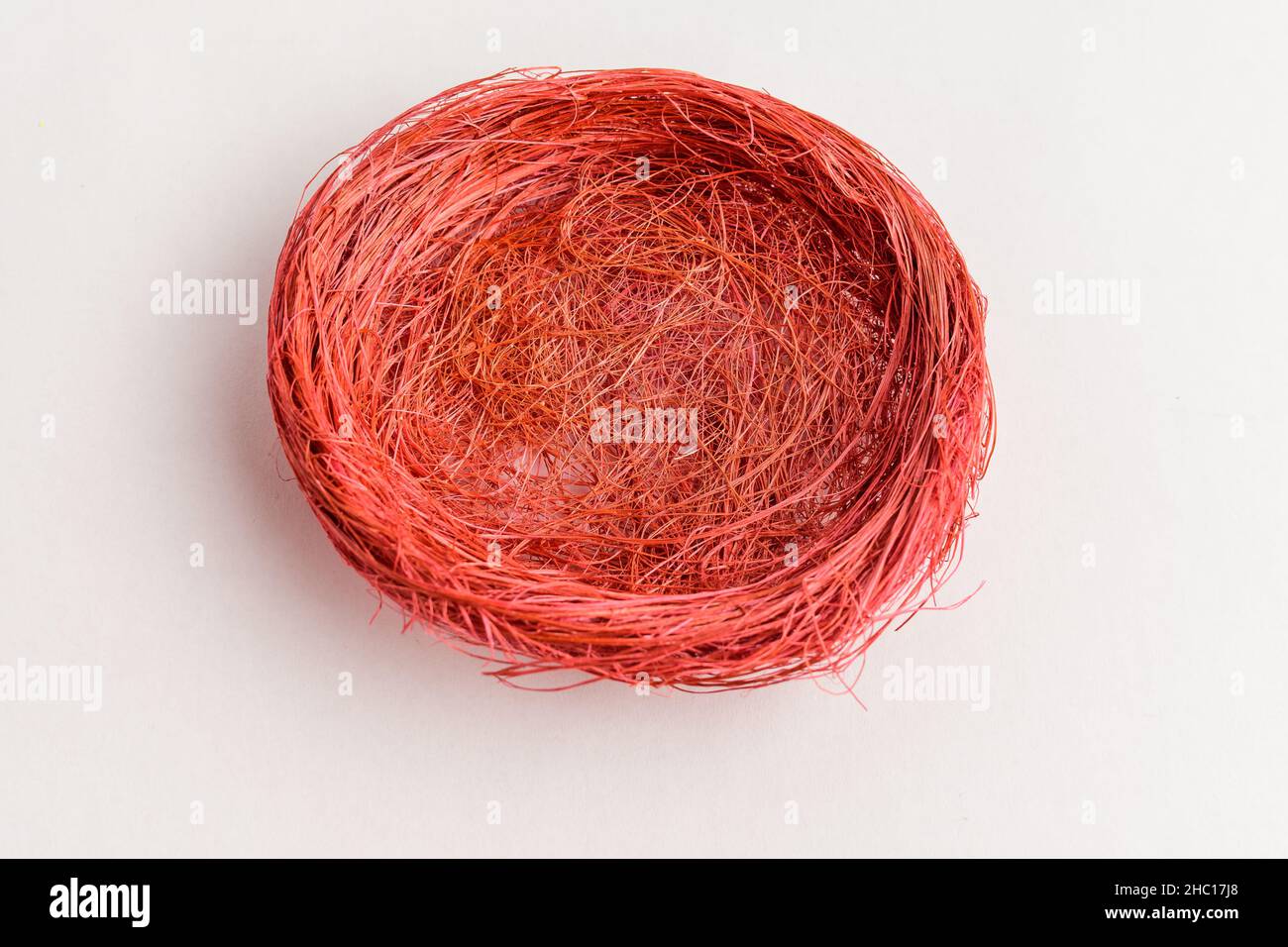 Empty red colored decorative rustic basket for Easter eggs or other decorations isolated on a white table Stock Photo