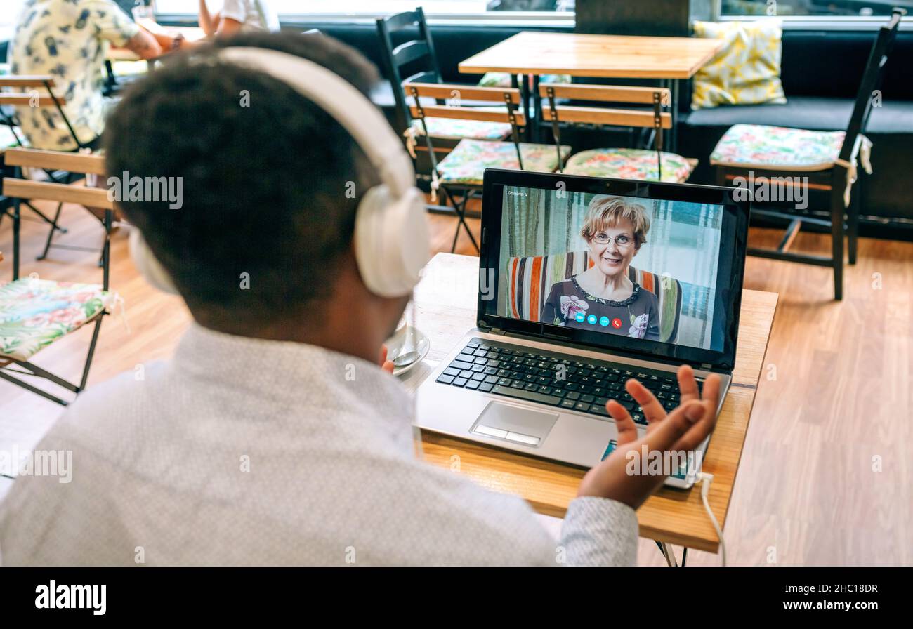 Man talking on video call with his mother from a cafeteria Stock Photo