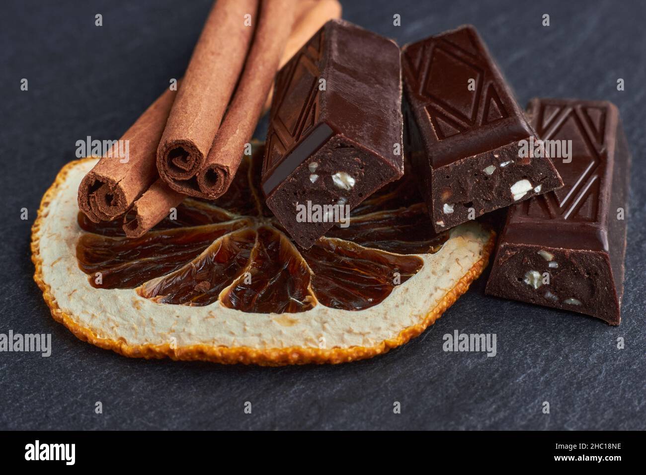 Dark chocolate bars with chopped almonds, dried orange wedges Stock