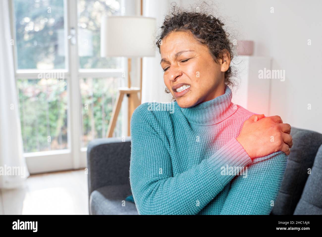 Black woman suffering shoulder pain because of poor posture Stock Photo