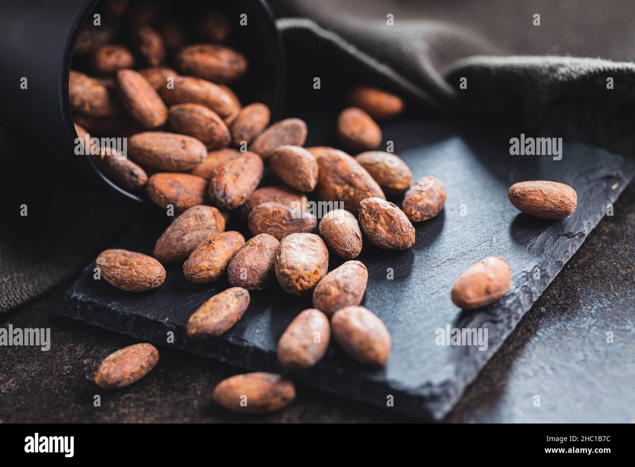 Dried cocoa beans. Cacao beans on kitchen table. Stock Photo