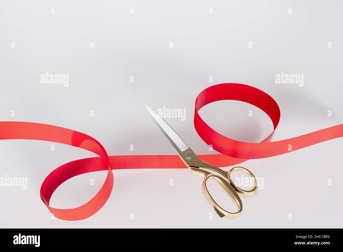 Red ribbon golden scissors cutting with Text space white background Stock Photo