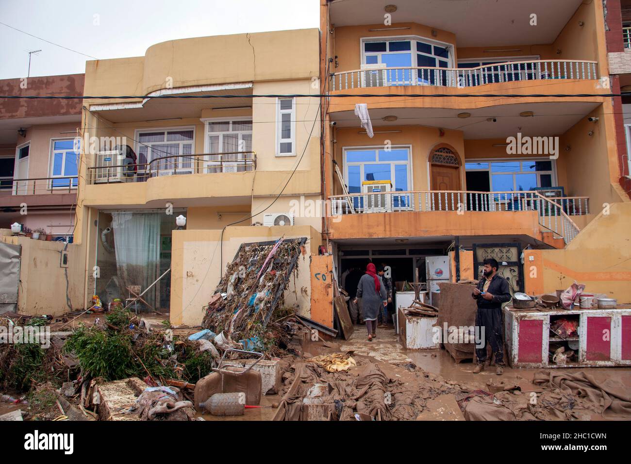 Erbil, Iraq. 17th Dec, 2021. People clean a house after flash floods in