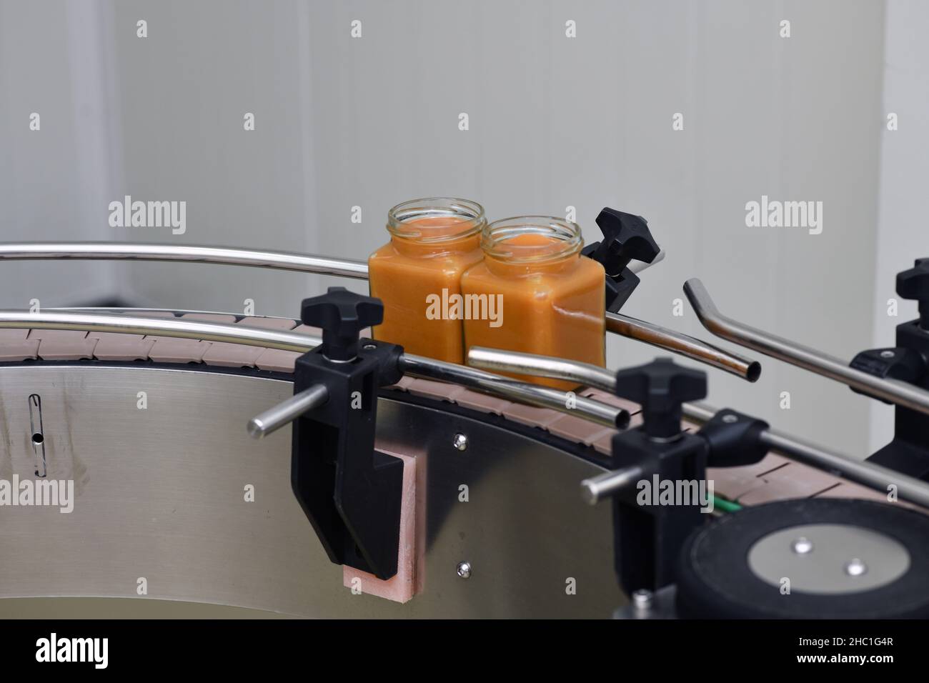 Jars of creamed honey in a packaging line at a commercial honey factory