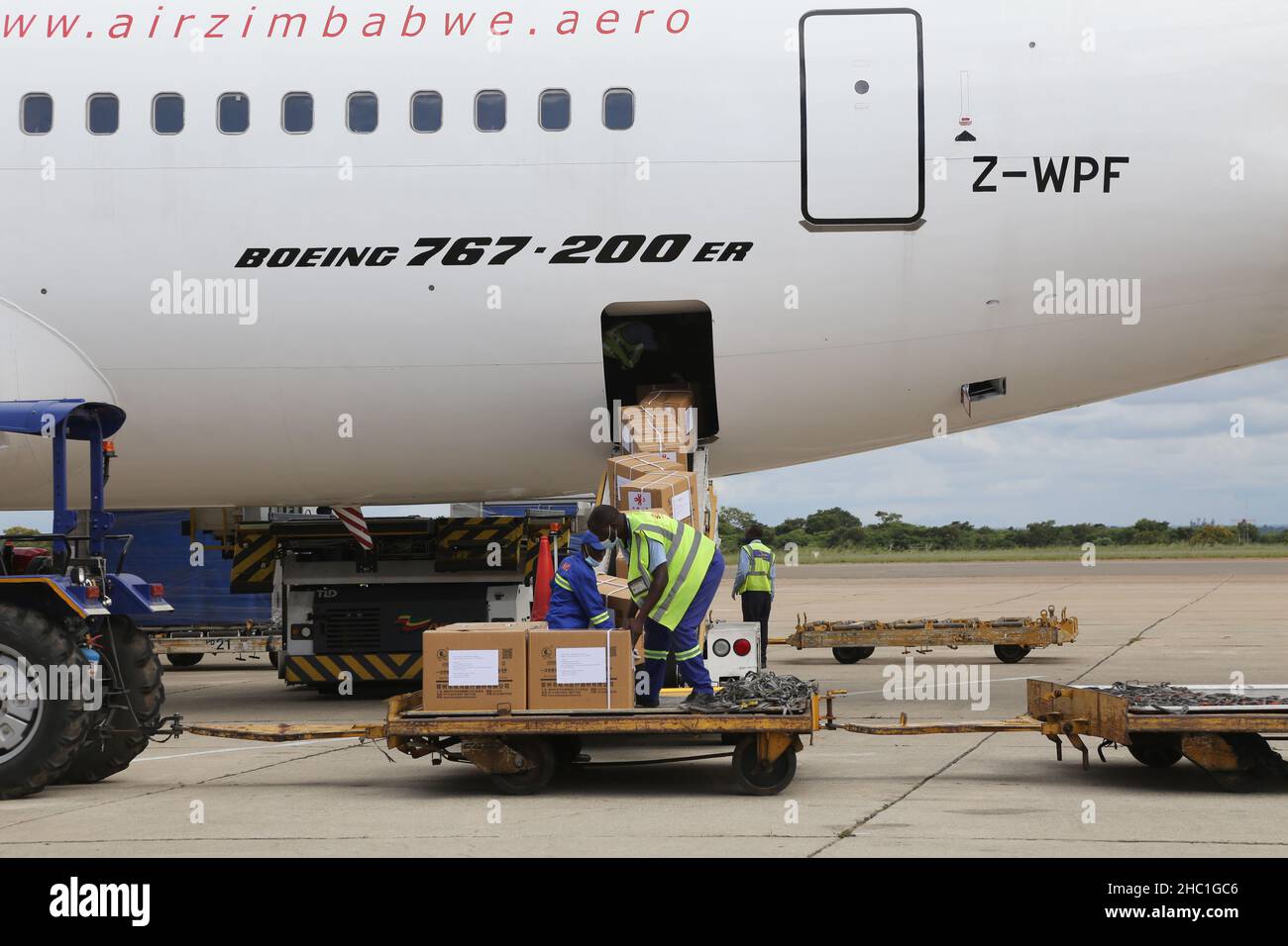 Harare, Zimbabwe. 20th Dec, 2021. Workers unload medical supplies donated by China at Robert Gabriel Mugabe International Airport in Harare, Zimbabwe, on Dec. 20, 2021. Zimbabwe on Monday received a batch of Sinovac COVID-19 vaccine donated by China, which will boost the country's vaccination campaign as it battles the fourth wave of COVID-19 pandemic. Credit: Zhang Yuliang/Xinhua/Alamy Live News Stock Photo