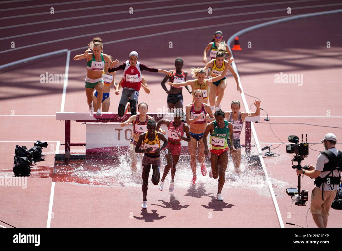 Female runners jumping the obstacle in the estuary in the 3000 meter ...