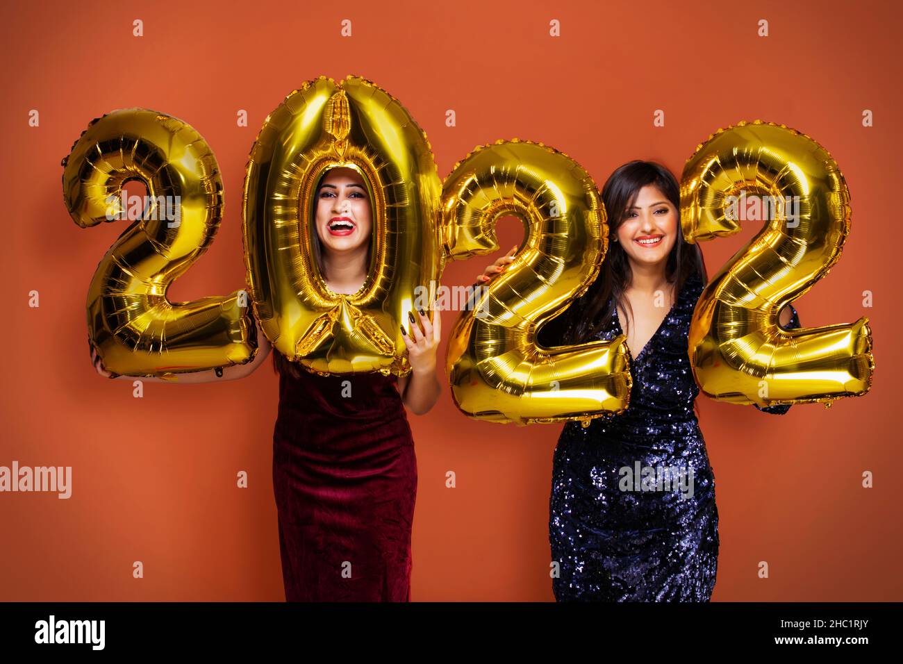 Young women holding 2022 golden balloons during a new year party Stock Photo