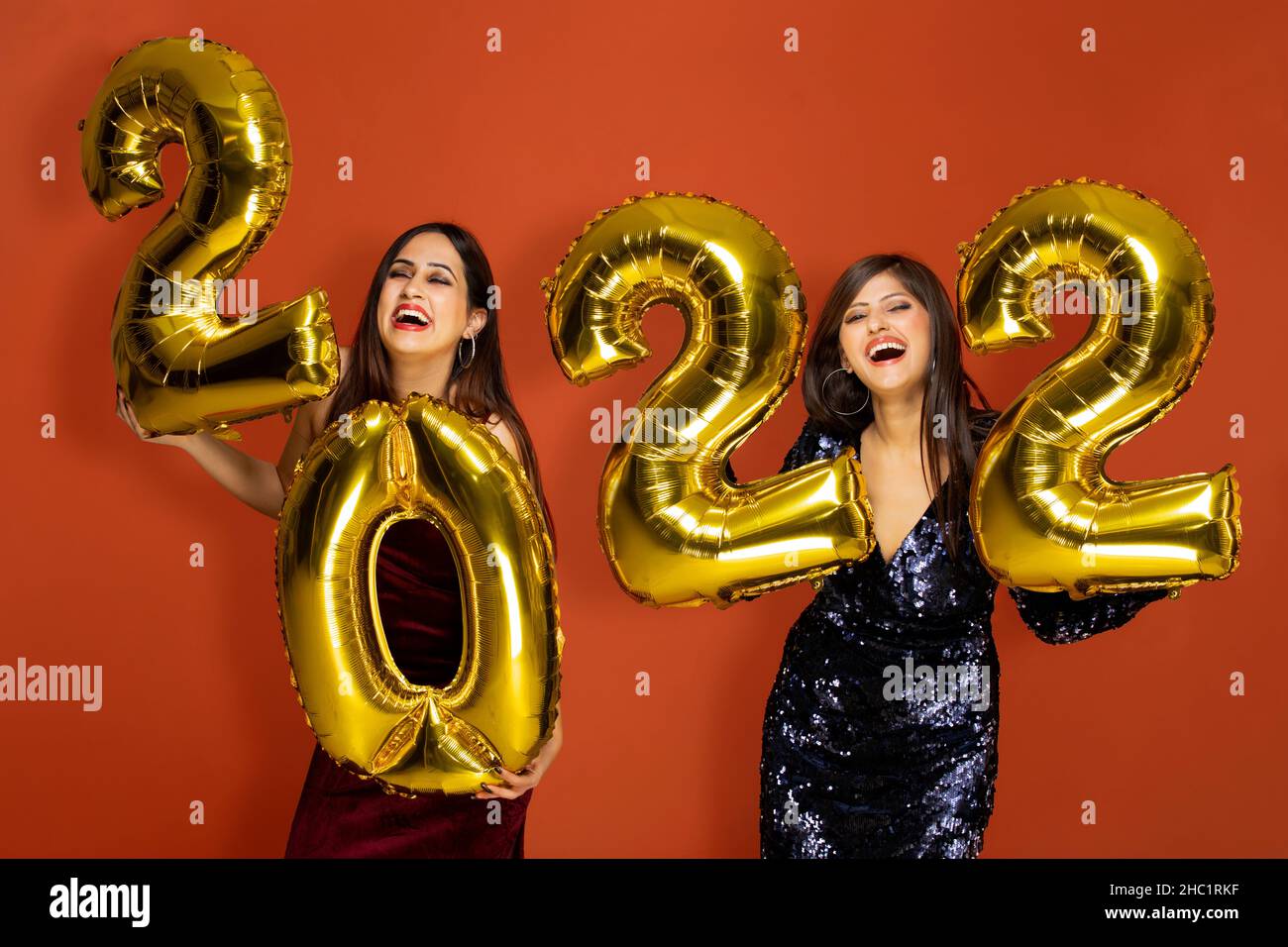 Young women holding 2022 golden balloons during a new year party Stock Photo