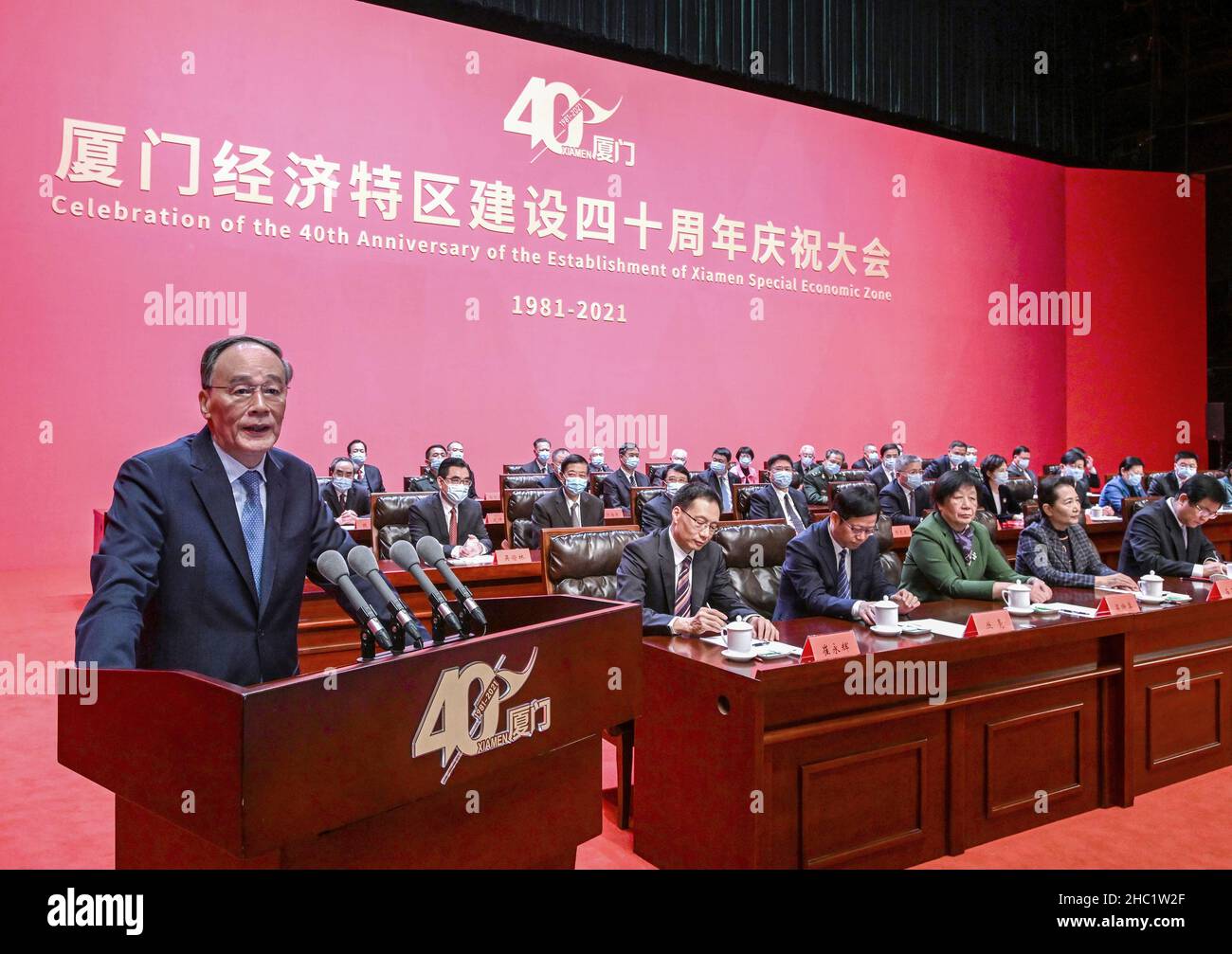 (211221) -- XIAMEN, Dec. 21, 2021 (Xinhua) -- Chinese Vice President Wang Qishan addresses a gathering marking the 40th anniversary of the establishment of the Xiamen Special Economic Zone (SEZ) in Xiamen, east China's Fujian Province, Dec. 21, 2021. Chinese President Xi Jinping has sent a congratulatory letter on the 40th anniversary of the establishment of the Xiamen SEZ. The letter by Xi, also general secretary of the Communist Party of China Central Committee and chairman of the Central Military Commission, was read out on Tuesday at the gathering. (Xinhua/Rao Aimin) Stock Photo