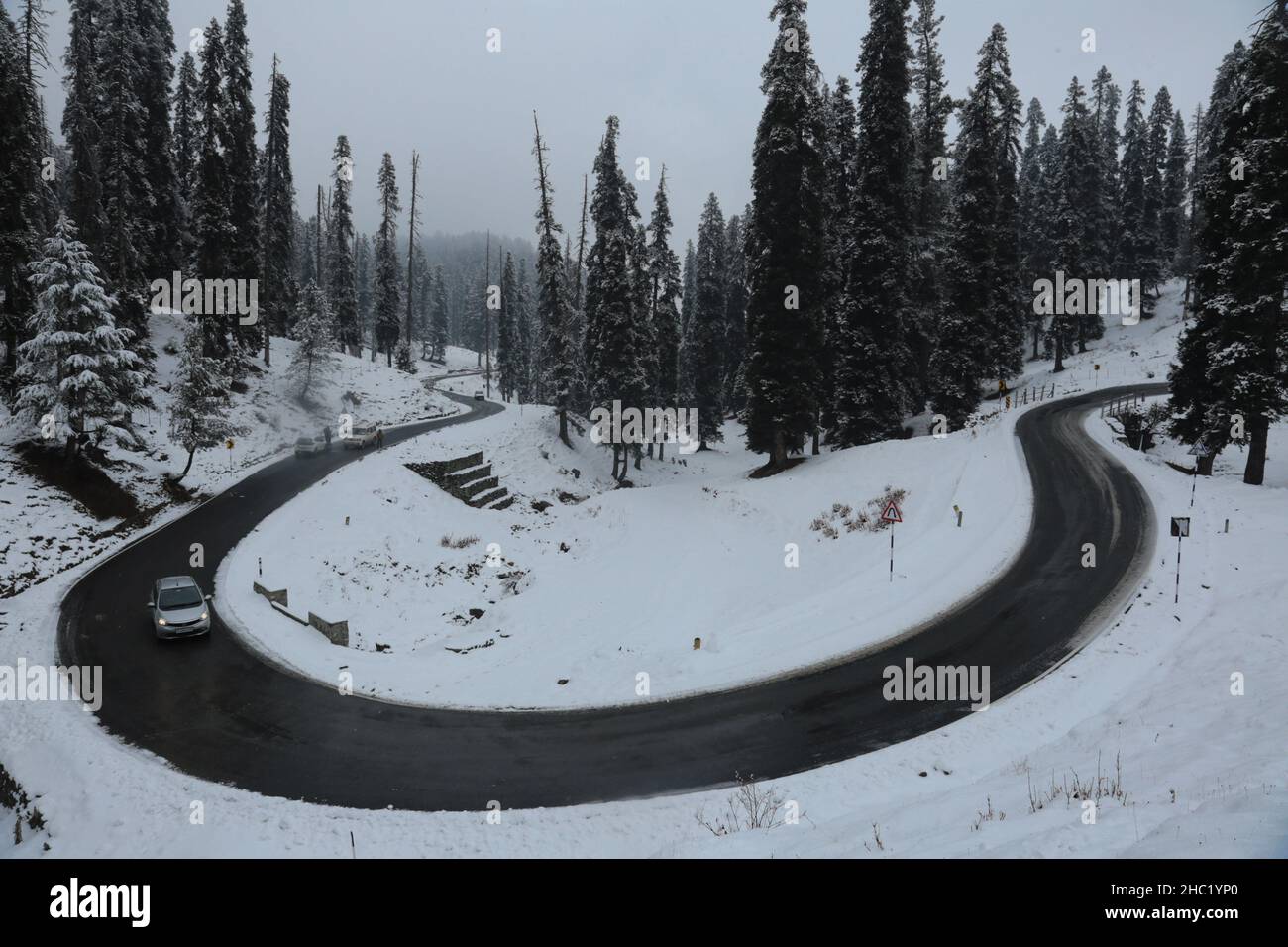 Srinagar, India. 23rd Dec, 2021. Vehicle passes snow covered road amid