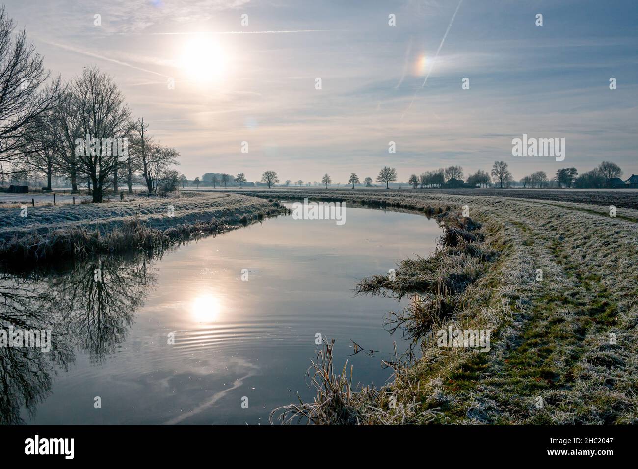 The flowing water in the canal 'the Soestwetering' in winter time with the frozen grass and reeds, near the village of Boerhaar in the province of Ove Stock Photo
