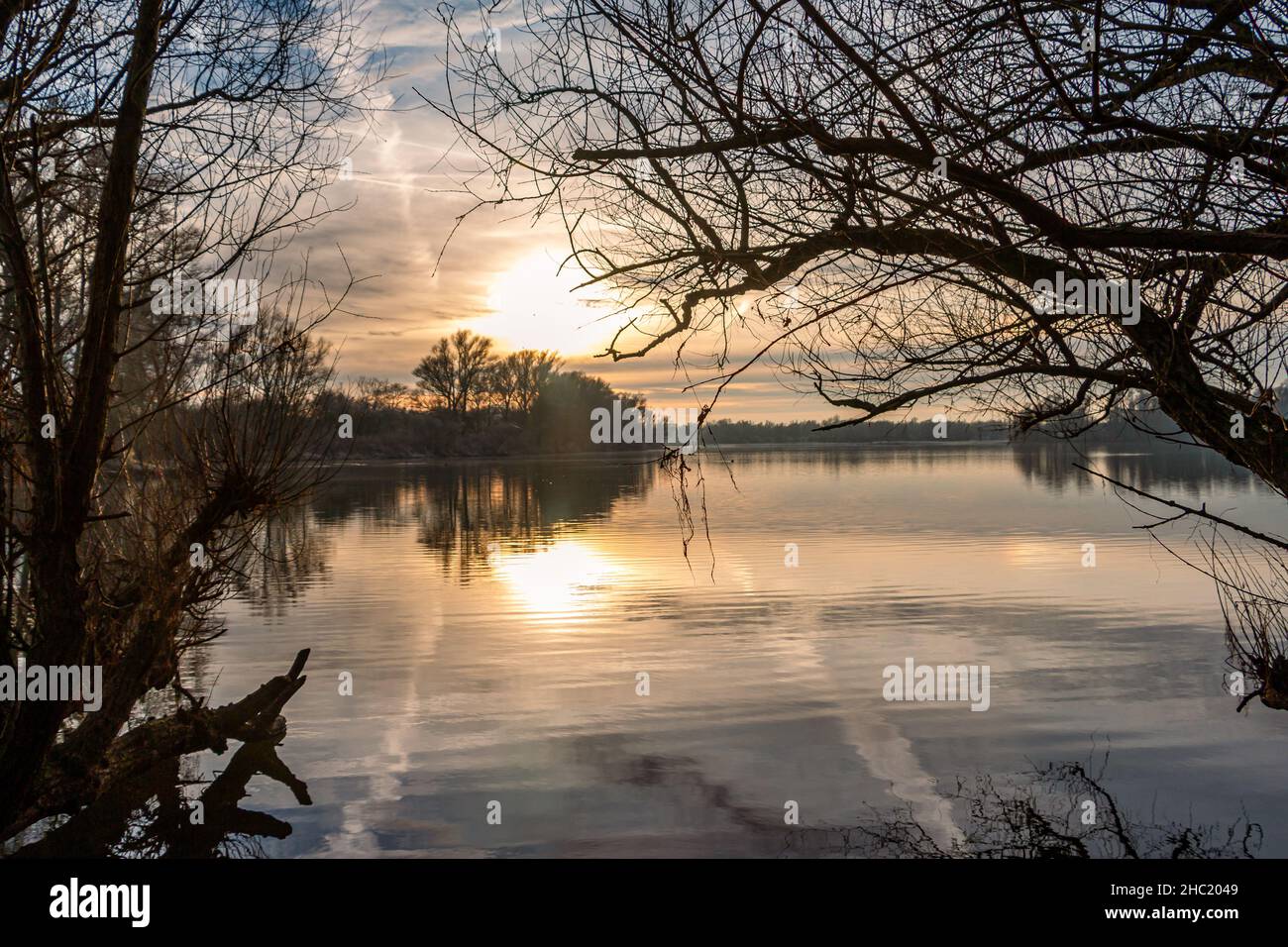 Beautiful sunset with orange and yellow gold colors in winter time at the floodplains of the rain river 'the IJssel' near the town of Olst-Wijhe in th Stock Photo