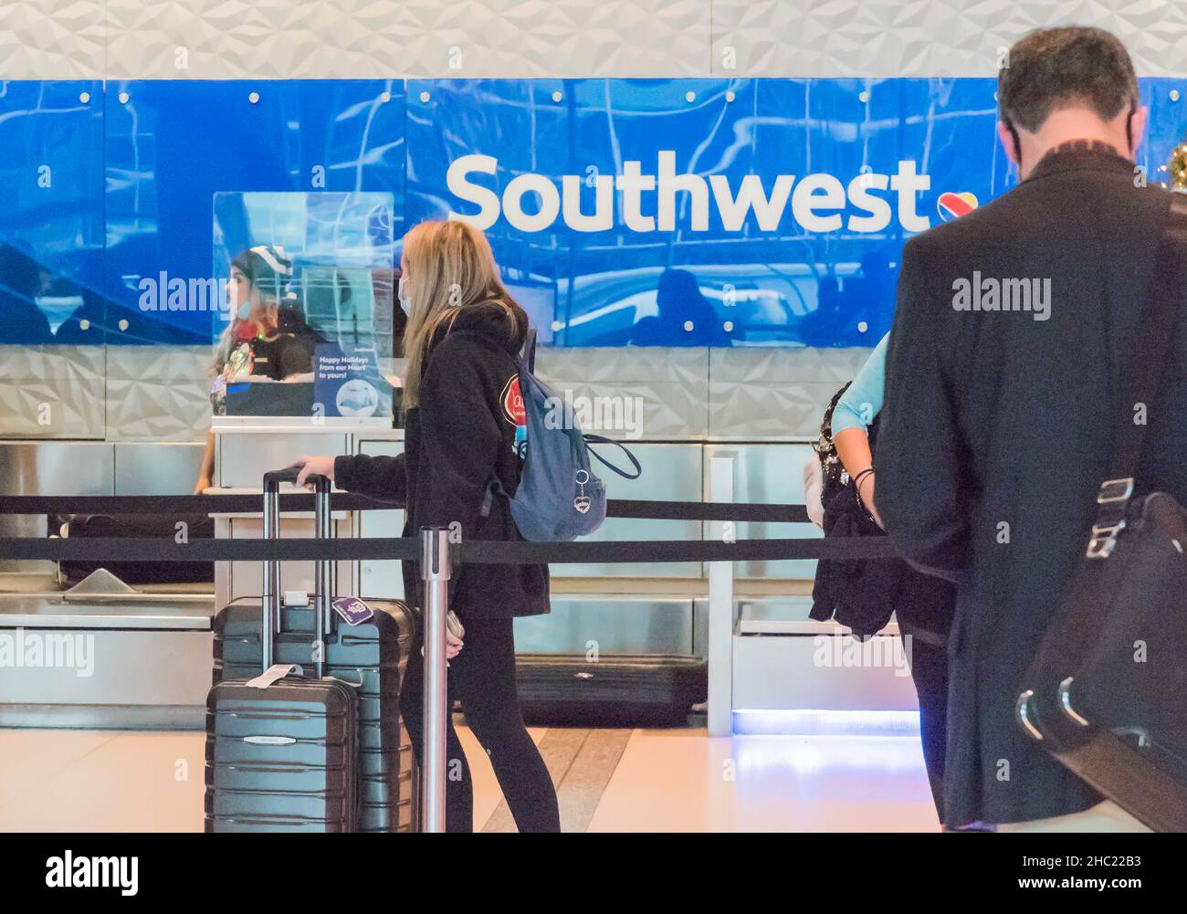 (211218) -- DALLAS, Dec. 18, 2021 (Xinhua) -- Travelers wait at the check-in counters of Southwest Airlines at Dallas Love Field Airport in Dallas, Texas, the United States, Dec. 17, 2021. Gary Kelly, CEO of Southwest Airlines, has tested positive for COVID-19, the company headquartered in Dallas of the U.S. state of Texas said Friday, two days after he attended a hearing in U.S. Senate along with some other U.S. airline chiefs and lawmakers. (Photo by Guangming Li/Xinhua) Stock Photo