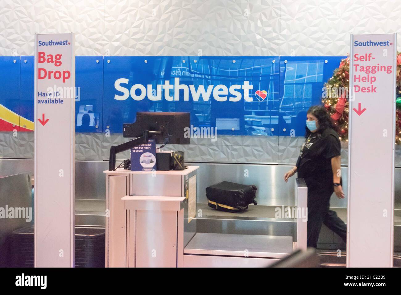 (211218) -- DALLAS, Dec. 18, 2021 (Xinhua) -- An agent of Southwest Airlines works at Dallas Love Field Airport in Dallas, Texas, the United States, Dec. 17, 2021. Gary Kelly, CEO of Southwest Airlines, has tested positive for COVID-19, the company headquartered in Dallas of the U.S. state of Texas said Friday, two days after he attended a hearing in U.S. Senate along with some other U.S. airline chiefs and lawmakers. (Photo by Guangming Li/Xinhua) Stock Photo