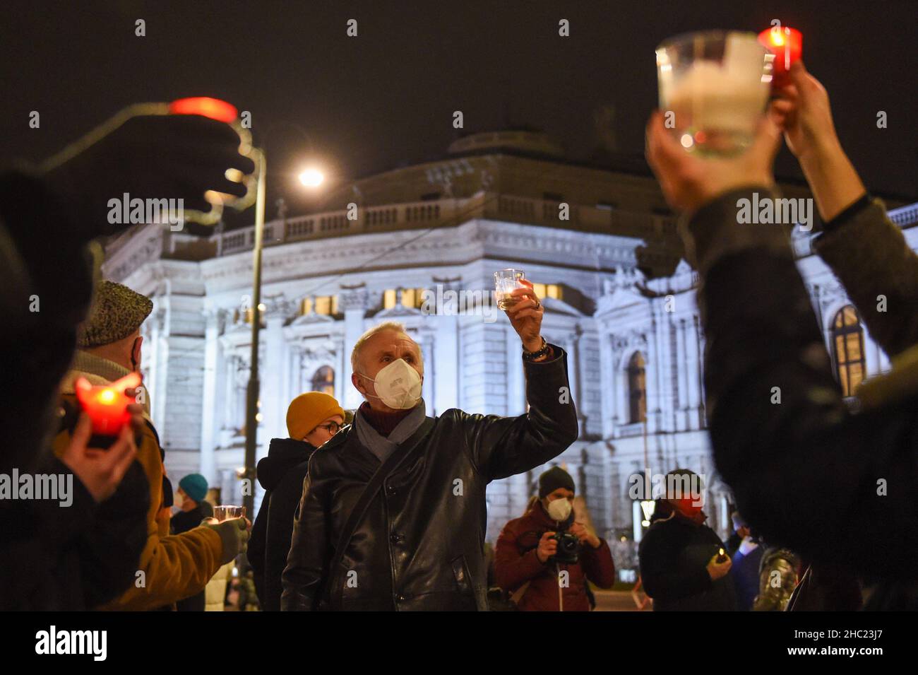 (211219) -- VIENNA, Dec. 19, 2021 (Xinhua) -- People hold candles to mourn the victims of COVID-19 during an event in Vienna, Austria, Dec. 19, 2021. A commemorative event was held here on Sunday to mourn the 13000 lives lost to COVID-19 in Austria. (Xinhua/Guo Chen) Stock Photo