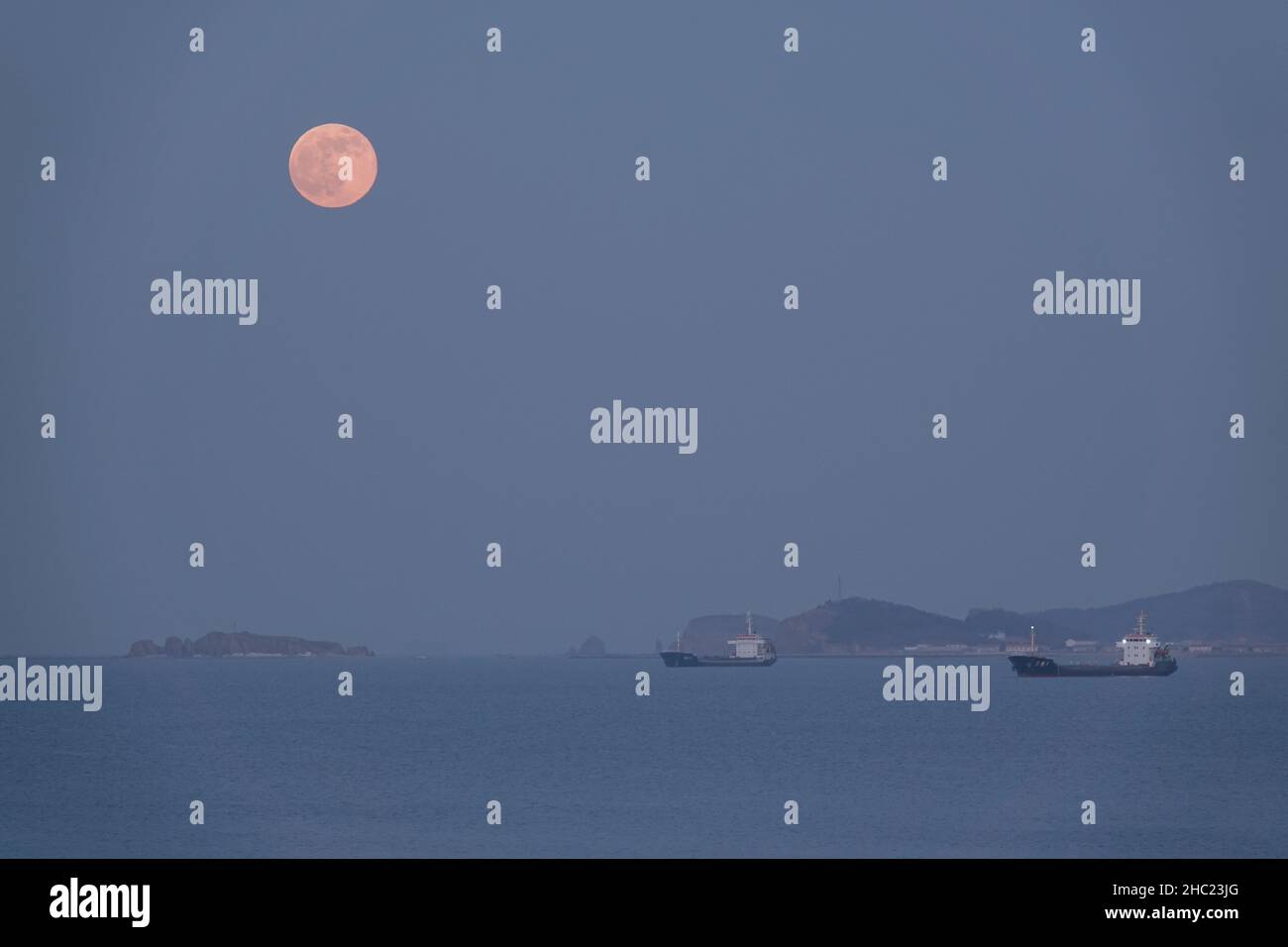 (211219) -- YANTAI, Dec. 19, 2021 (Xinhua) -- Photo taken on Dec. 19, 2021 shows the full moon in Yantai City, east China's Shandong Province. The last full moon in the year of 2021 appeared on Sunday, the sixteenth day on the eleventh month of the Chinese lunar calendar. (Photo by Tang Ke/Xinhua) Stock Photo