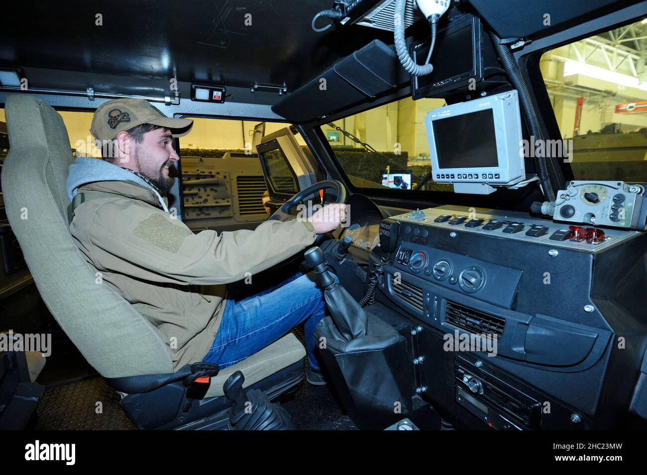 Man sitting on a driver-mechanic s cabin of armored personnel carrier and holding a wheel. Exhibition Arms and Safety-2018 . October 12, 2018. Kiev, U Stock Photo