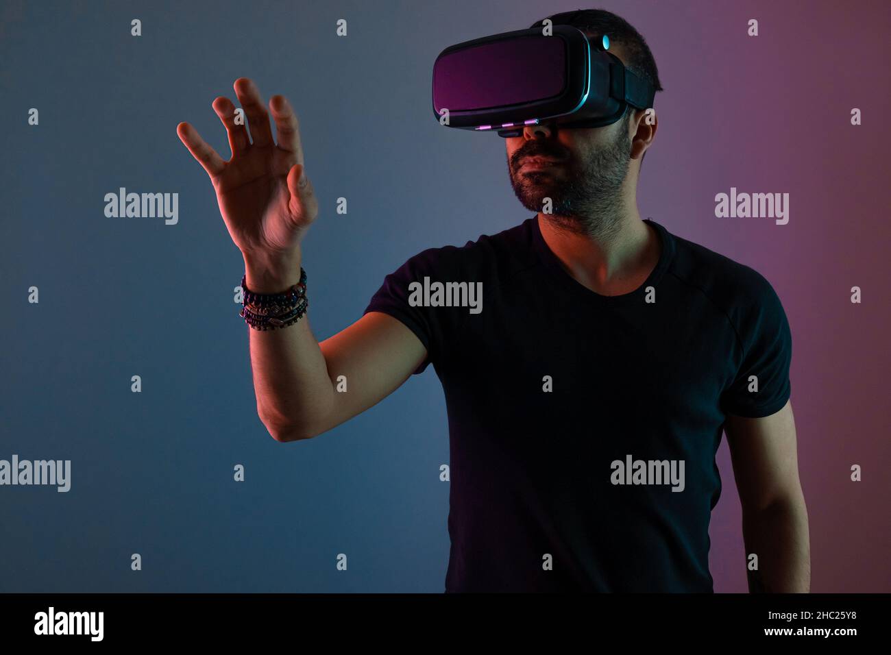 Young man in VR glasses headset interact with virtual reality in color ...